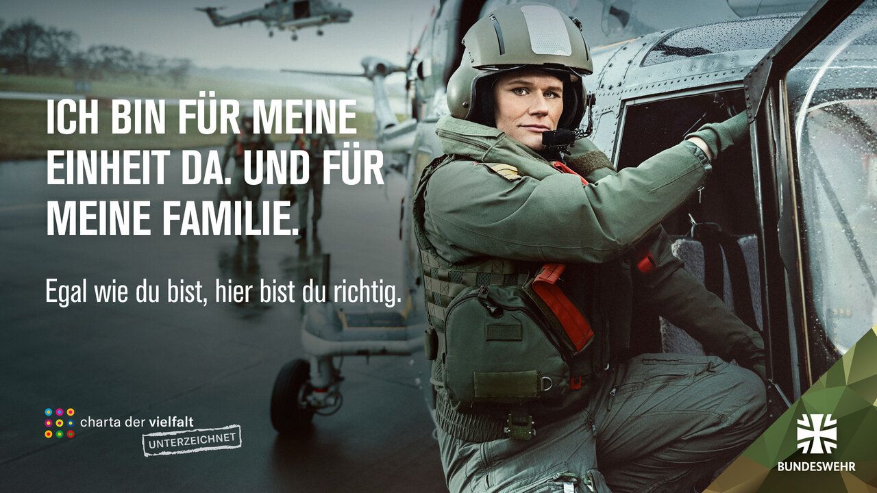 Eine Soldatin steht neben einem Hubschrauber. Der Slogan: "Ich bin für meine Einheit da. Und für meine Familie."