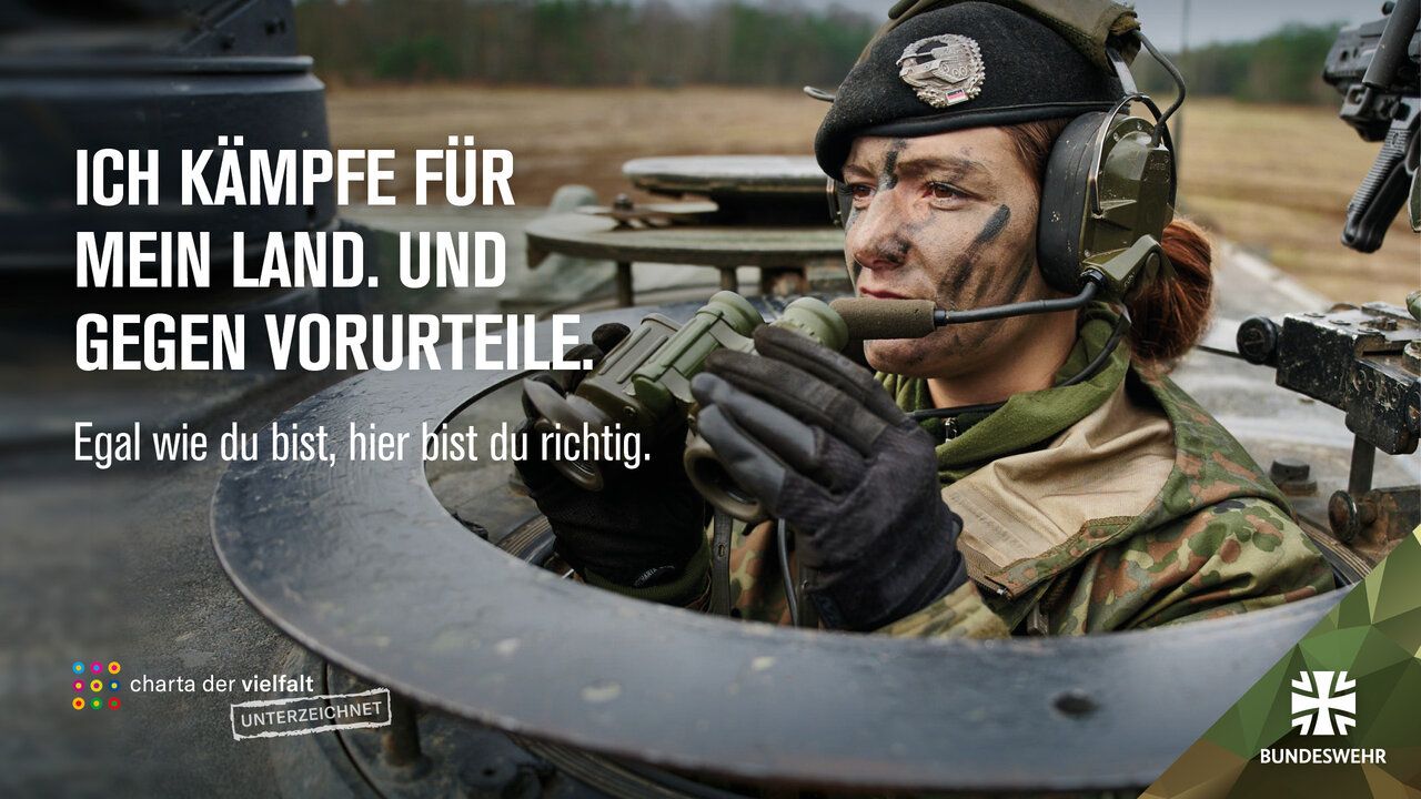 Eine Soldatin schaut mit einem Fernglas aus einem Panzer. Der Slogan: Ich kämpfe für Mein Land. Und gegen Vorurteile ist im Bild zu sehen.