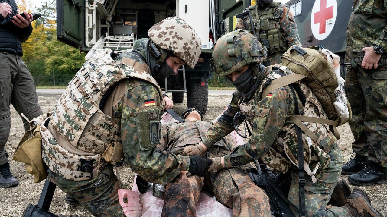 Soldaten der Sanitätstruppe versorgen einen verwundeten Kameraden. 