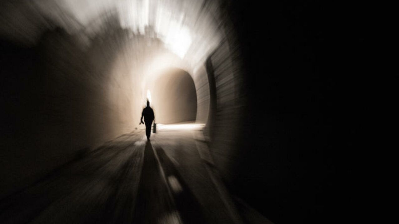 Eine Person geht durch einen Tunnel