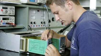Ein zivil Angestellter der Bundeswehr verrichtet elektronische Arbeiten.