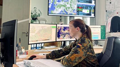 Eine Soldatin sitzt vor einem Computer