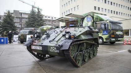 Ein Fahrzeug vom Typ Wiesel steht vor einem Karrieretruck der Bundeswehr 