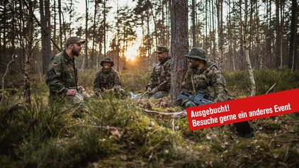 Eine Gruppe Soldaten im Gespräch im Wald.