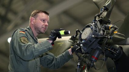 Soldat inspiziert Heckrotor einen NH-90