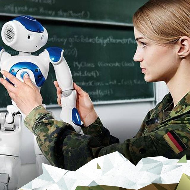 Eine Studentin der Bundeswehr in einem Klassenraum mit einem kleinen Roboter.