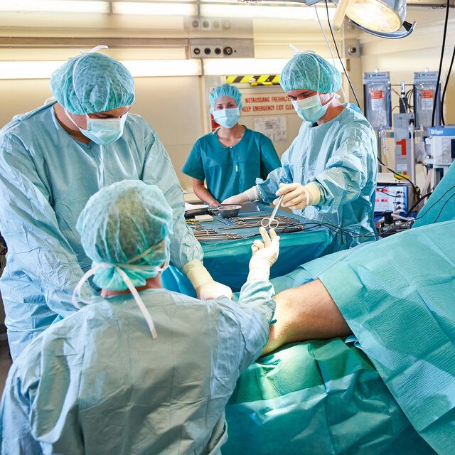 Ärztinnen und Ärzte nehmen an einer Operationssituation im OP teil. 