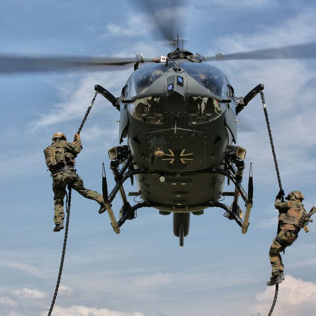 Soldat_innen seilen sich während eines Fluges aus dem Hubschrauber ab.