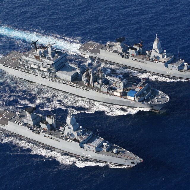 Drei Schiffe der Bundeswehr fahren im schnellen Tempo nebeneinander über die See.