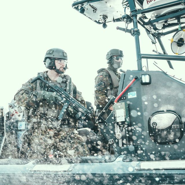 Zwei Soldaten auf hoher See befinden sich auf einem Kampfboot.