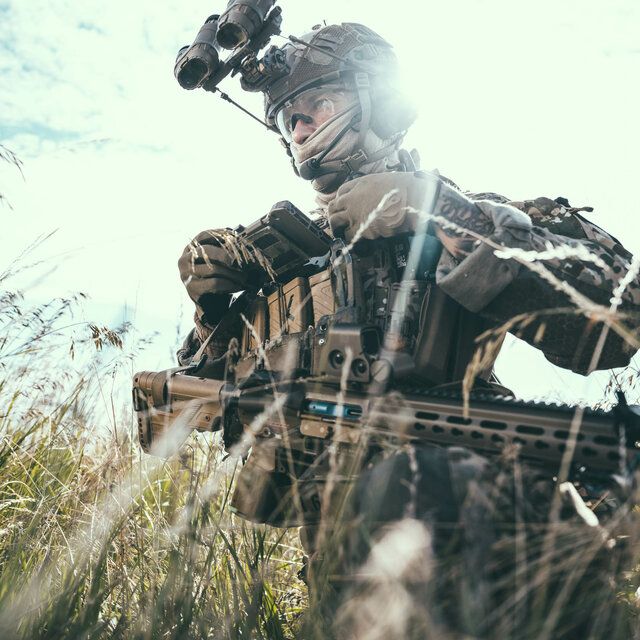 Ein Soldat der SpezialkrÃ¤fte steht mit SpezialausrÃ¼stung in einem dichten Feld.