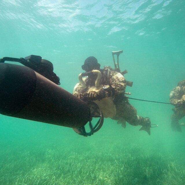 Zwei Soldaten der Bundeswehr bewegen sich mit einem Unterwasser-Scooter durchs Wasser.