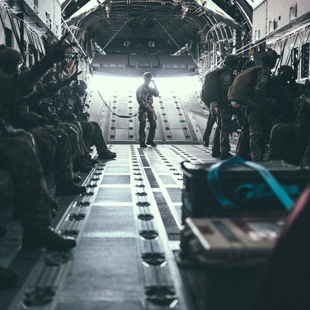 Eine Gruppe von Soldat_innen der SpezialkrÃ¤fte macht sich zum Absprung aus dem Flugzeug bereit. 